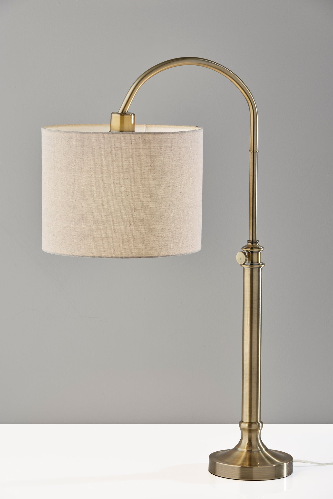 32" Antiqued Brass Metal Adjustable Cylinder Arched Table Lamp With Beige Drum Shade