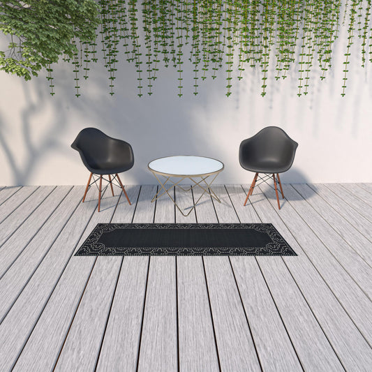 2' X 8' Black and Ivory Stain Resistant Indoor Outdoor Area Rug